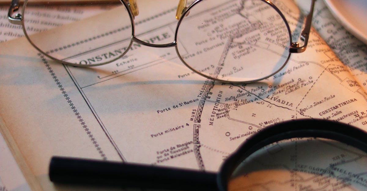 Eyeglasses and magnifying glass on a vintage map suggesting discovery and exploration.